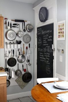 a kitchen with a chalkboard and pots and pans hanging on the wall