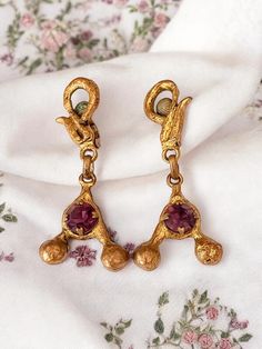 Beautiful pair of vintage clip-on earrings. Length of 6 cm. In good condition with some signs of wear visible in the photos. The earrings feature a unique Y-shaped design, adorned with pink-purple stones in the center. Ideal for adding a touch of retro elegance to your outfit. Vintage Single Dangle Clip-on Earring, Vintage Single Clip-on Earring In Metal, Brass Dangle Clip-on Earrings, Rose Violette, Vintage Clip, Purple Stones, Pink Purple, Clip On Earrings, Gold Metal