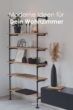 a book shelf with books and vases on it in front of a white wall