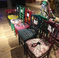 a row of colorful chairs sitting on top of a wooden floor