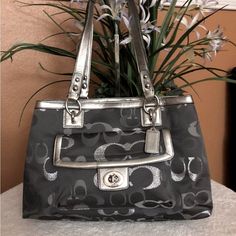 Coach Penelope Lurex Gallery Signature Optic Colors: Silver/Charcoal/Gray Serial N-G1275-F20443 Large Size Leather Trim Silver Tone Hardware Inside 2 Multifunctional Slip Pockets And 1 Zippered Two Main Compartments With Magnetic Snap Closure And One Middle Zipper Compartment Interior Pink Sateen Fabric New With Out Tag See All Pictures For More Details And Condition Measurements: 15 3/4”(L) X 10 1/2” (H ) X 3 1/2” (D) Double Strap 7.5” 100 % Authentic Smoke/Pet Free Home Please Check Out My Other Listing For More Bags And Purses. Thanks Bags And Purses, Charcoal Gray, Leather Trim, Coach Bags, Charcoal Grey, Leather Trims, Snap Closure, Black Silver, Large Size