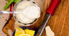 a wooden cutting board topped with sliced lemons next to a jar of ranch dressing