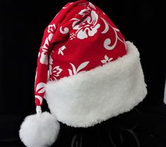 "If you have a tropical Santa in your home he or she may need a hat. This novelty Santa hat is made up in a Christmas red and white Hawaiian traditional hibiscus print cotton fabric. Hat is decorated with a snowy white faux Sherpa fur fabric trim. Put Santa in a tropical island mode for that balmy warm holiday season. The sizing on the hat is generous and will fit most adult head sizes. The styling is a slouch cone, traditional Santa look. There is a snowy white pompom stitched on the top. Openi Luau Christmas Party Outfit, Chrismas Party Outfit, Hawaiian Christmas Outfit, Adjustable Red Hats For Holiday, Adjustable Red Hat For Holiday, Christmas In Hawaii Party, Happy Huladays, White Christmas Holiday Hat, Hawaii Christmas Hat