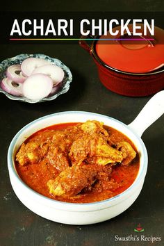 there is a bowl of chicken curry next to some onions and an onion on the table