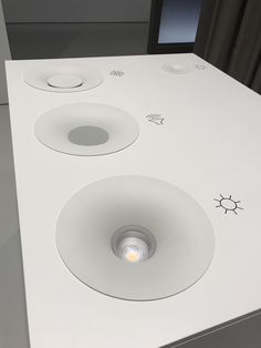 a white counter top with three lights on each side and an object in the middle