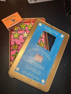 two birthday candles are in a box on the table next to some scissors and a pair of scissors