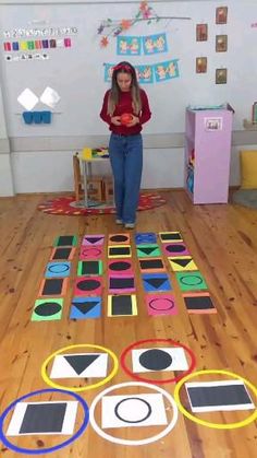 a woman standing on top of a wooden floor next to an array of circles and squares