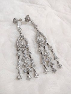 These earrings are to DIE for!! These stunning beautiful pieces are authentic 1920s art deco rhinestone. The silver tone pot metal is loaded with rhinestones and has a screw back style. These are SUPER long and GORGEOUS!! These are PERFECT for the Gatsby wedding or themed event. Please see all pictures on this pair for a better description and sizing. 13 Vintage Diamond Clip-on Earrings, Vintage Clip-on Diamond Earrings For Anniversary, Silver Clip-on Diamond Earrings, Silver Diamond Clip-on Earrings, Vintage Clip-on White Gold Earrings, Vintage White Gold Clip-on Earrings, Victorian Screw Back Earrings For Wedding, Victorian Screw Back Wedding Earrings, Vintage Pierced Diamond Earrings For Formal Events