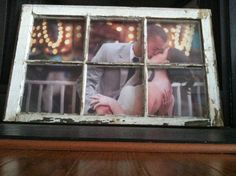 an old window frame with a photo of a man and woman kissing in front of them