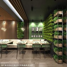 a dining room with green walls and plants on the wall