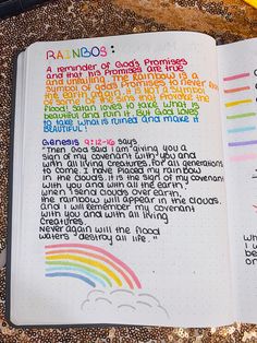 an open bible with rainbows written on it and a pen next to the book