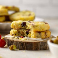 three cookies stacked on top of each other with cherries around the edges and one broken in half