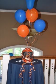 balloons are in the shape of a helmet on top of a table with a blue cloth