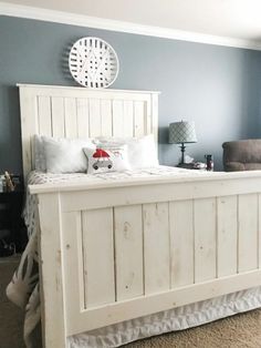 a white bed sitting in a bedroom next to a chair