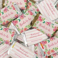 candy bar wrappers with pink flowers and gold foil wrapped in striped paper, on top of each other