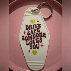 a white keychain with the words drive safe someone loves you written on it