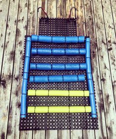 an array of blue and yellow pegs are arranged on a wooden floor in order to make it look like they have been made out of legos