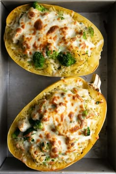 two stuffed squash halves with cheese and broccoli on them in a baking pan