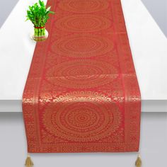 a red table runner with a plant on it