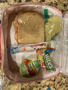 the lunch bag is packed with bread, cheese, yogurt and other snacks