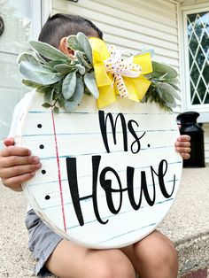 a young boy sitting on the steps holding up a sign that says, mrs rowe