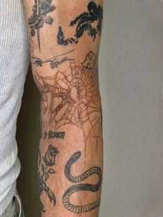 a man's arm with tattoos on it, including a snake and other things