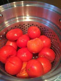 tomatoes in a strainer basket ready to be washed and put into the water for cooking