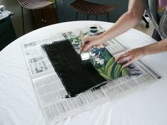 a man is cutting paper on top of a table