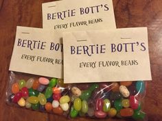 three bags filled with jelly beans sitting on top of a wooden table