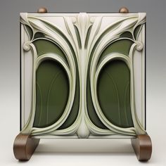 an art deco cabinet with wooden wheels and handles on the front, in white and green