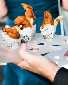 two people holding trays with food on them and one person handing it to the other