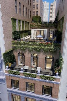 an apartment building with balconies and plants growing on the top floor, from above