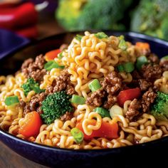 a close up of a bowl of noodles with meat and broccoli on the side