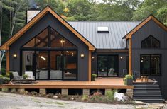 a house that is in the woods with lots of windows and stairs leading up to it