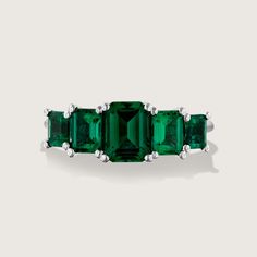 Spectacular. Stunning. Unforgettable. In our new Alexandrina ring we created a goldsmith masterpiece unlike anything else. Five large and deep-green emeralds are elevated above the ring with an elegant bridge decorated with our signature sign, forming an architectural perfection on your finger. It's not just a bling, the skilled craftsmanship and unique design turn the Alexandrina ring into a true heirloom that will never go out of style and will be passed through generations. **Due to the nature of the natural Emerald the color may vary** All features can be customized! please contact us if you wish to make changes, we love making custom designs. All of our jewelry is carefully handmade in our atelier *HC diamond are all conflict free diamonds To order by phone click here>> +972(0)7229910 Timeless Baguette Cut Green Emerald Ring, Timeless Green Baguette-cut Emerald Ring, Timeless Green Baguette Cut Emerald Ring, Timeless Emerald Ring With Accent Stones, Luxury Emerald Ring With Round Cut, Timeless Tsavorite Green Jewelry, Formal Fine Jewelry Emerald Ring, Emerald Ring With Baguette Cut Center Stone, Emerald Ring With Center Stone In Baguette Cut