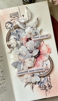 an open book with some flowers on it