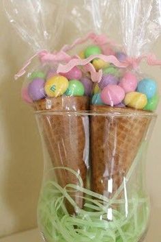 an ice cream cone filled with candies and easter eggs in a clear plastic bag