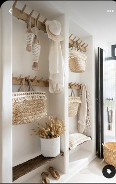 an entry way with baskets and hats hanging on the wall