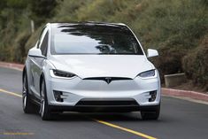 a white tesla electric car driving down the road