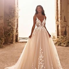 a woman standing in front of an archway wearing a wedding dress