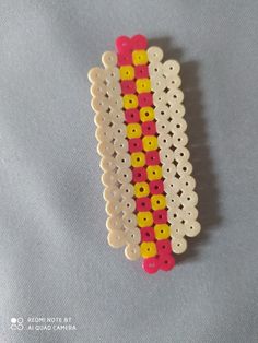 two pieces of white, yellow and red beaded brooch with holes in the middle