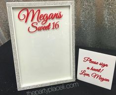 a white frame with red lettering on it next to a sign that says, megans sweet 16