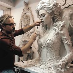 a man is painting a statue of a woman