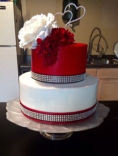 a white and red wedding cake sitting on top of a table