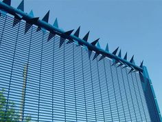 a blue wire fence with spikes on it