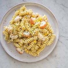 a white plate topped with pasta and shrimp