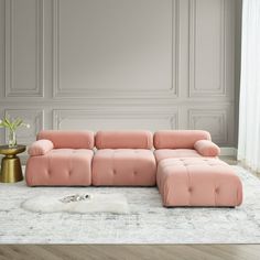 a pink couch sitting on top of a white rug