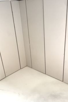 the corner of a room with white walls and no one sitting on the floor or standing in it