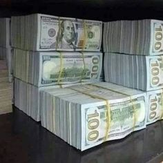 stacks of $ 100 bills sitting on top of each other in front of a window