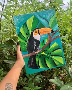 a painting of a toucan perched on a tree branch with leaves surrounding it